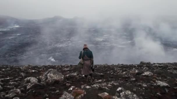 Drone of Man in groot jasje staand door mistig landschap — Stockvideo