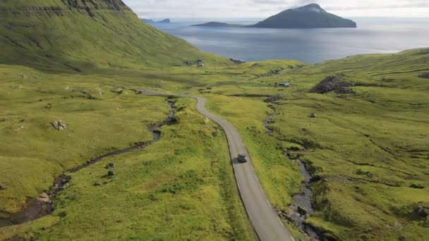 Drone της οδήγησης αυτοκινήτων κατά μήκος του δρόμου ανέμου σε Δραματική Countryside του νησιού Faroe — Αρχείο Βίντεο