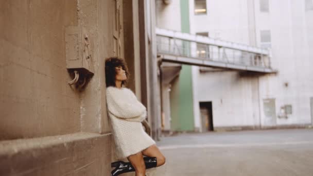 Sorrindo jovem modelo encostado contra a parede no vestido de lã — Vídeo de Stock