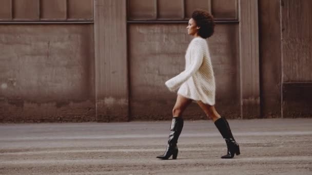 Frau in Wollkleid und Stiefeln mit windgebeugten Afro-Haaren — Stockvideo