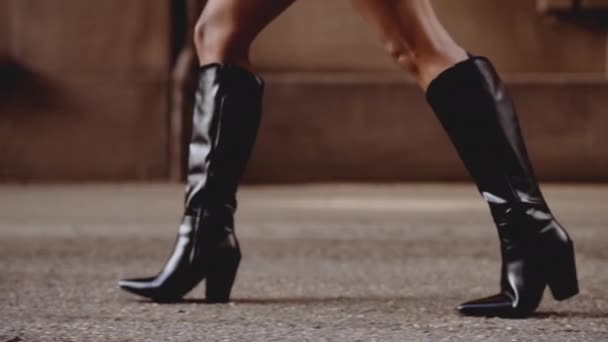 Uśmiechnięta młoda kobieta w butach spacerująca wzdłuż ulicy — Wideo stockowe