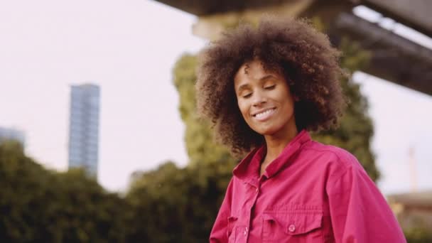 Mujer joven sonriente con el pelo afro en la moda rosa brillante — Vídeos de Stock