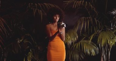 Turuncu Giysili Afro Saçlı Kadın Klasik Kamera Kullanıyor