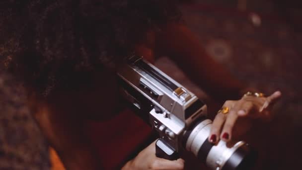Žena s afro vlasy natáčení s ročníkem 8Mm kamera — Stock video