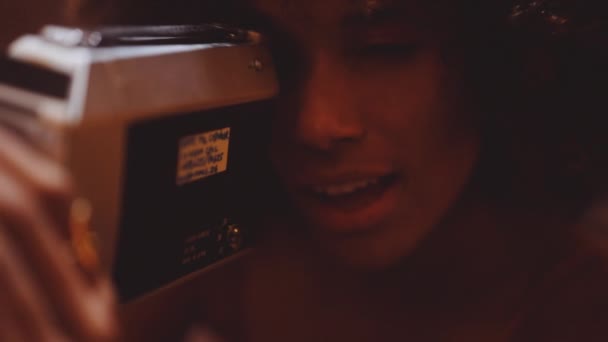 Kvinna med afro hår tittar igenom vintage 8Mm kamera — Stockvideo