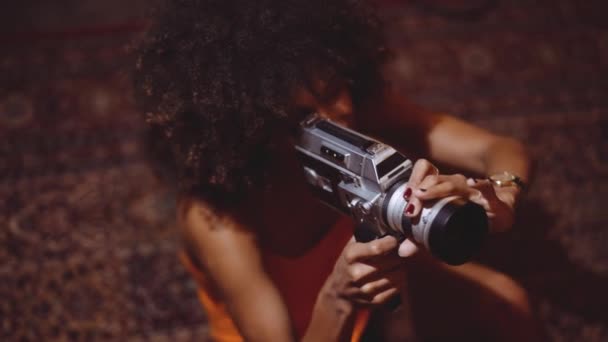 Turuncu Giysili Afro Saçlı Kadın Klasik Kamera Kullanıyor — Stok video