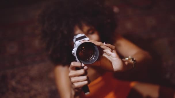 Γυναίκα με αφρό μαλλιά σε πορτοκαλί φόρεμα χρησιμοποιώντας Vintage 8mm κάμερα — Αρχείο Βίντεο