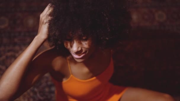 Vrouw met afro haar in oranje jurk glimlachen naar camera — Stockvideo