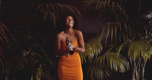 Mujer riendo con el pelo afro en naranja usando la cámara vintage de 8mm — Vídeo de stock