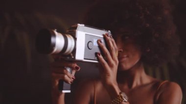 Afro saçlı kadın Vintage 8Mm Kamera kullanıyor.