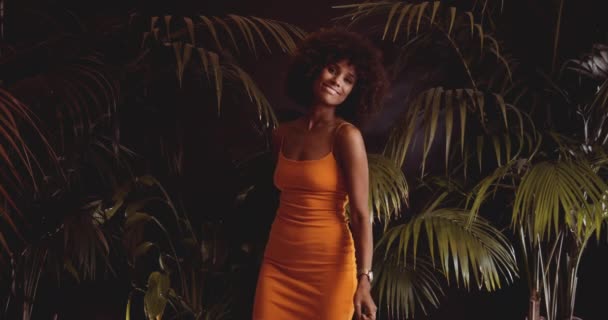 Afro saçlı, turuncu elbiseli, klasik 8Mm kameralı kadın. — Stok video