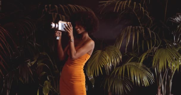 Afro saçlı gülümseyen kadın Vintage 8Mm Kamera kullanıyor. — Stok video