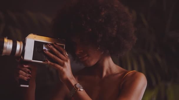 Žena s afro vlasy natáčení s ročníkem 8Mm kamera — Stock video