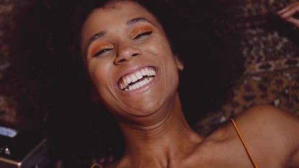 Mujer con pelo afro riéndose con cámara vintage de 8mm — Vídeo de stock