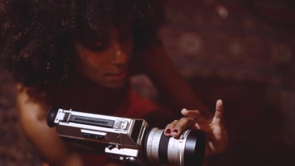 Femme avec afro cheveux focalisant caméra vintage 8mm — Video