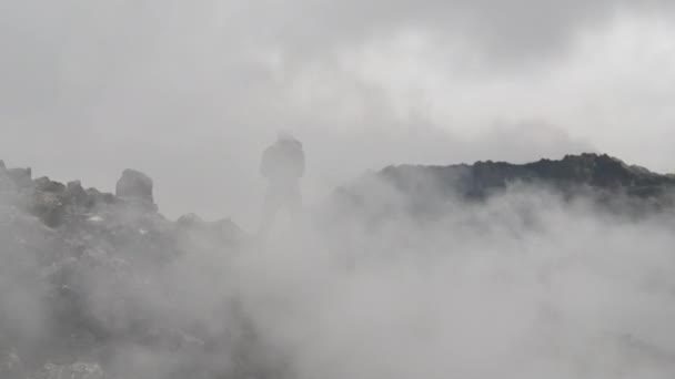 Fotograf wśród gęstego dymu na skałach pola lawy — Wideo stockowe
