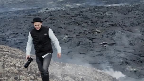Fotografo a piedi come il fumo sorge dal campo di lava dietro — Video Stock