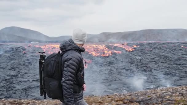 Fotógrafo Caminhando com Rucksack Perto de Fluir Lava — Vídeo de Stock