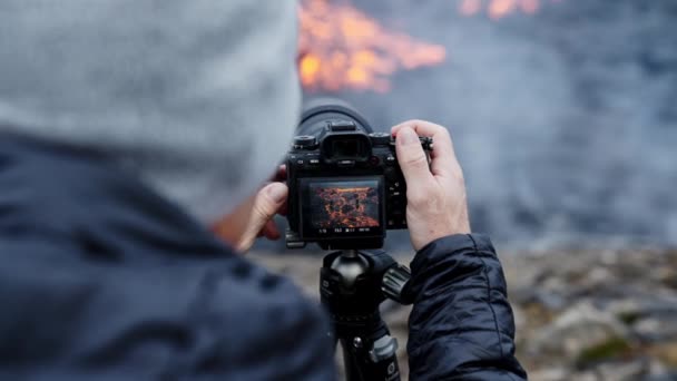 Fotografo che regola la fotocamera su treppiede con flusso di lava — Video Stock