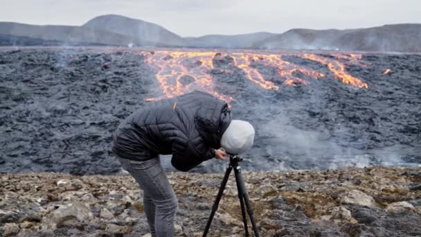Photographer Looking Through Camera To Flowing Lava — Stock Video