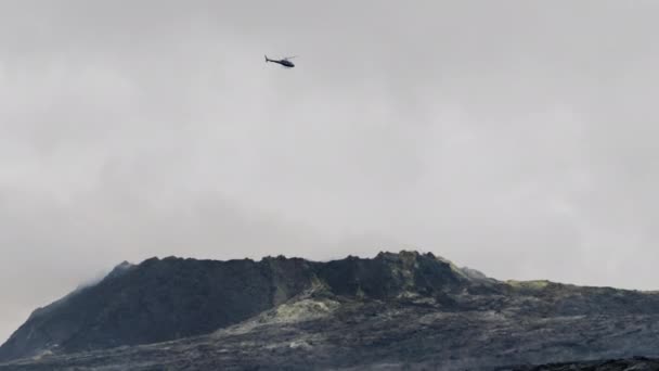 Helicóptero volando por encima de fumar campo de lava — Vídeo de stock