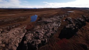 Kayaların üzerinde güneş ışığını yansıtan göllerle İHA uçuşu