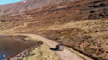 Fjord 'dan dağdaki şelaleye doğru giden yoldaki araba.
