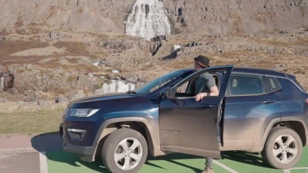 Muž v autě při pohledu na horský vodopád — Stock video