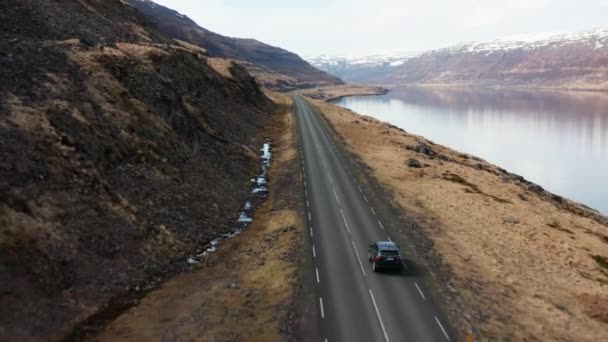 Carro de rastreamento de drones dirigindo pelo fiorde e para as montanhas — Vídeo de Stock