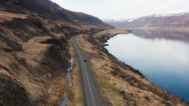 Voiture de suivi de drone conduisant par le fjord et vers les montagnes — Video