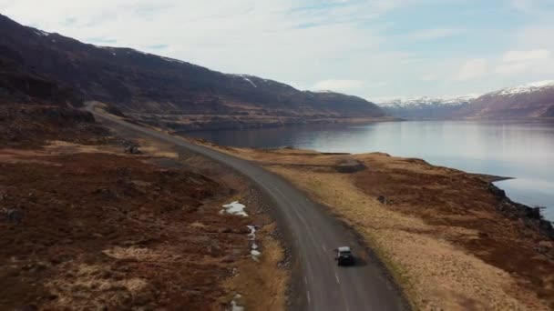 Drönare spårning bil körning med fjord och mot bergen — Stockvideo