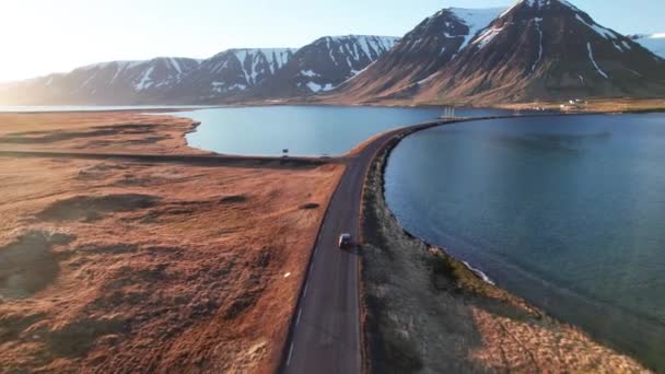 Drönare av bil körning på väg över fjordar mot bergen — Stockvideo