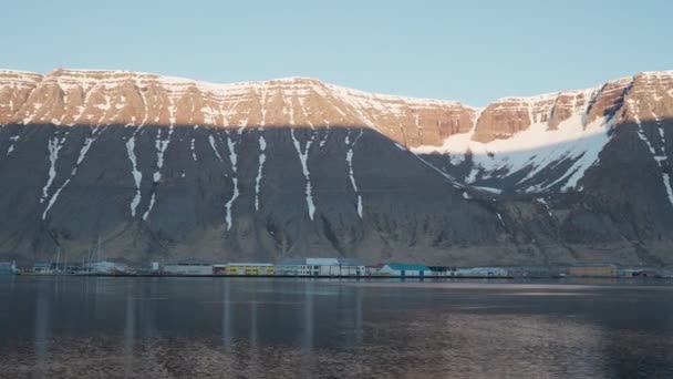 Fjord med majestätiska solbelysta berg över byn — Stockvideo