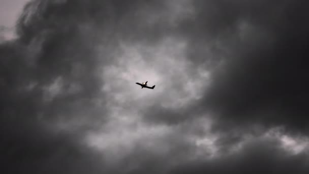 明里上空の暗い雲にもかかわらず空を飛ぶ飛行機 — ストック動画