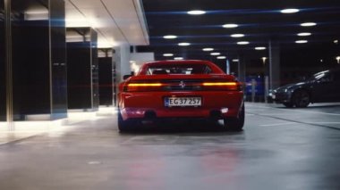 Kırmızı Ferrari 348 tüberküloz arka ışıkları açık bir garaja park edildi.