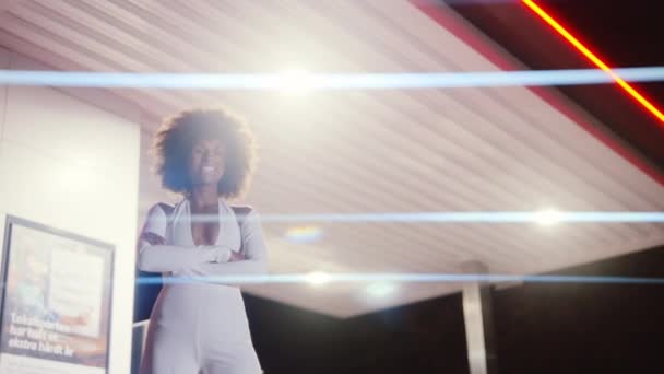 Femme avec Afro en combinaison posant dans la station-service la nuit — Video