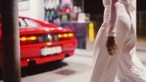 穿连衣裙的妇女步行通过红色法拉利348号加油站 — 图库视频影像