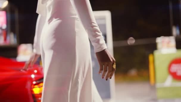 Vrouw in jumpsuit ronde en aanraken van rode Ferrari in tankstation — Stockvideo