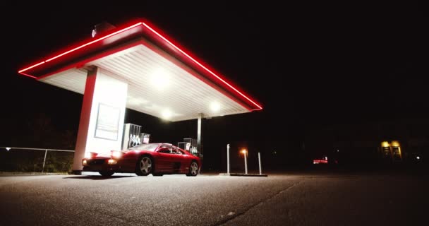 Rode Ferrari 348 TB rijden van tankstation 's nachts — Stockvideo