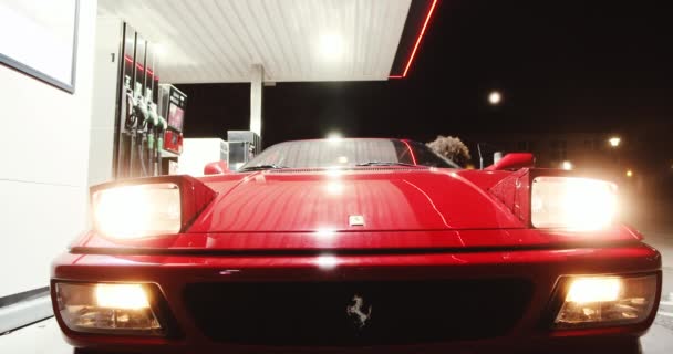 Mulher de macacão saindo de Ferrari vermelho no posto de gasolina — Vídeo de Stock