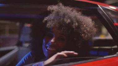 Kameraya gülümseyen afro saçlı kadın Ferrari 348 tüberküloz.