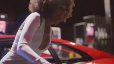 Kırmızı Ferrari 'den çıkan Afro saçlı kadın. Geceleri 348 tüberküloz.
