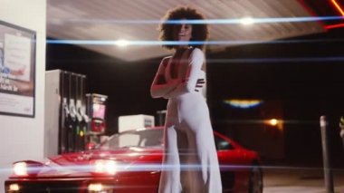 Kırmızı Ferrari 348 tüberküloz önünde kolları katlanmış, tulumlu kadın.