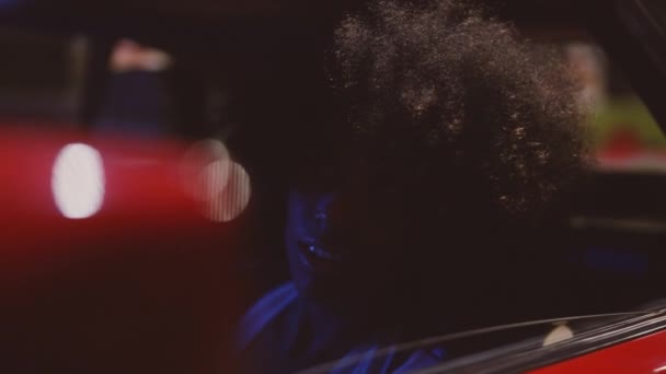 Mujer sonriente con cabello afro en Ferrari 348 TB por la noche — Vídeo de stock