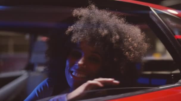 Vrouw met afro haar glimlachen naar camera in Ferrari 348 TB 's nachts — Stockvideo