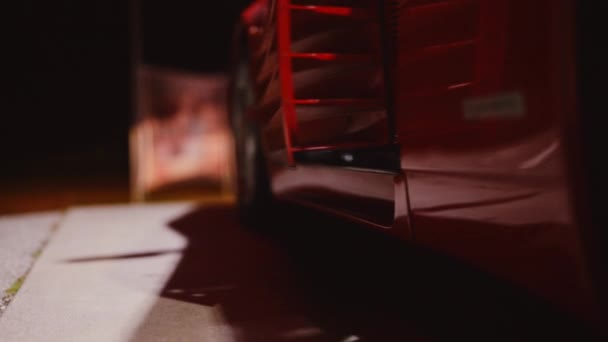 Žena vystupuje z červené Ferrari 348 TB zaparkované v garáži