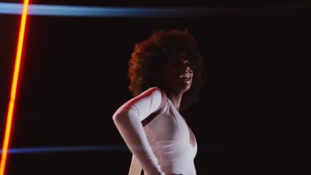 Donna con afro in tuta posa in distributore di benzina di notte — Video Stock