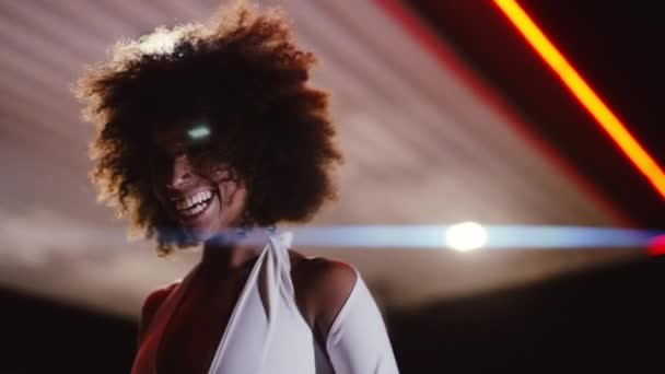 Vrouw met afro in jumpsuit poseren in tankstation 's nachts — Stockvideo