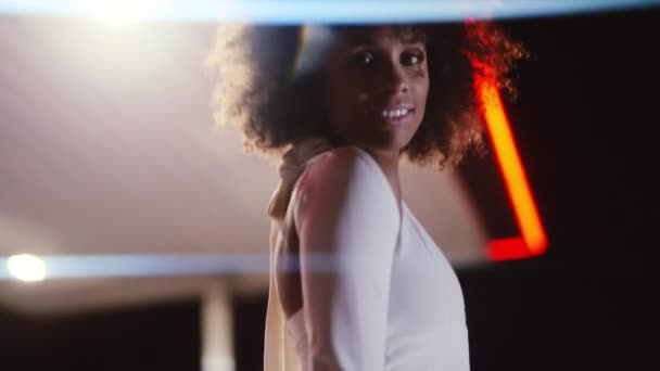 ผู้หญิงที่มี Afro ใน Jumpsuit โพสในปั๊มน้ํามันในเวลากลางคืน — วีดีโอสต็อก