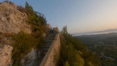 Drone merdivenlerin üstünde ve kadın gün batımında gözlem noktasında